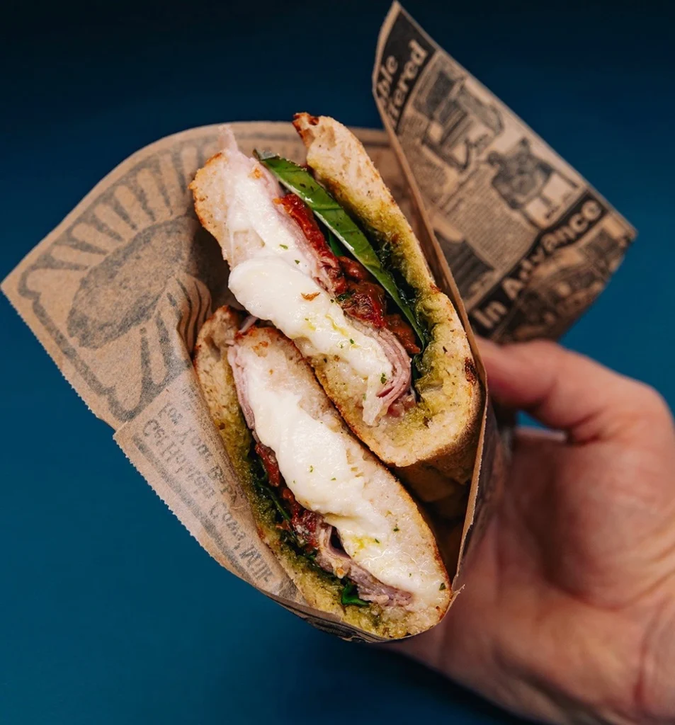 Main tenant un sandwich italien préparé dans un restaurant