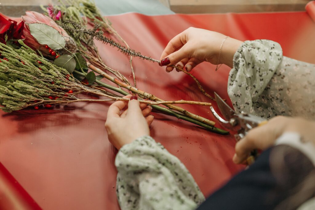 Une femme est en train d'assembler un bouquet de fleurs